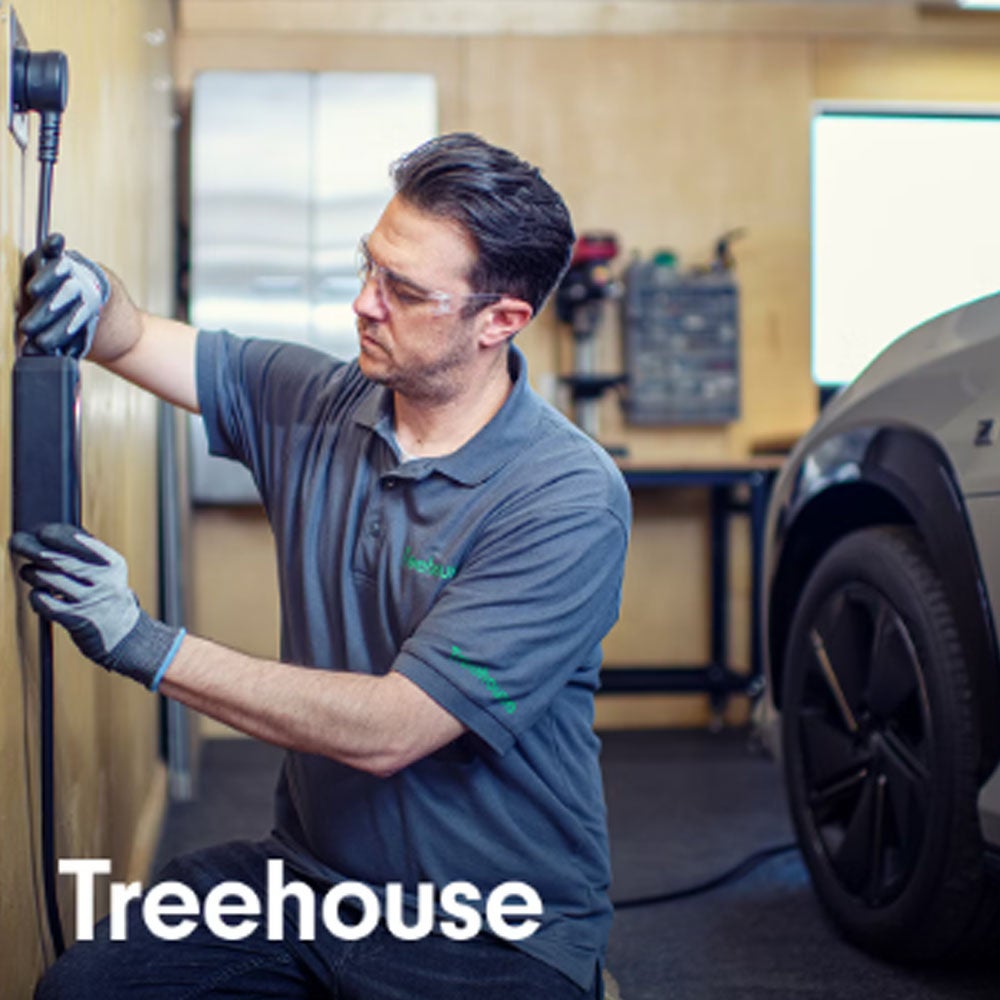 A person plugs a charger into their vehicle's charging port.