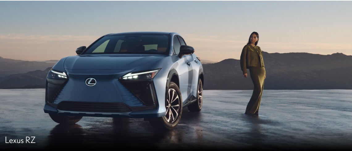 A Blue Lexus UX drives on a snowy road. A Grey Lexus NX parked in front of a wall